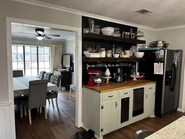 kitchen featuring wood counters, ceiling fan, dark wood-type flooring, crown molding, and stainless steel refrigerator with ice dispenser