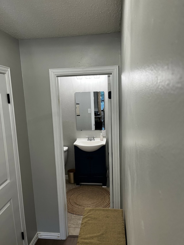 hall featuring a textured ceiling and sink