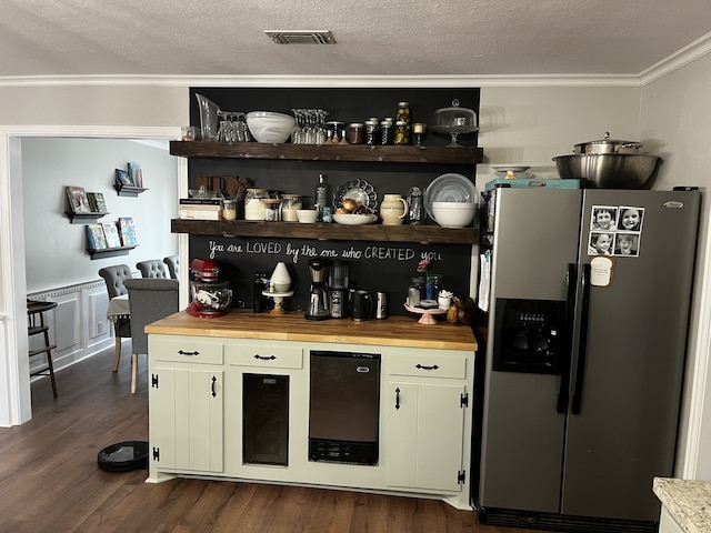 bar with dark hardwood / wood-style flooring, stainless steel fridge with ice dispenser, a textured ceiling, ornamental molding, and butcher block counters