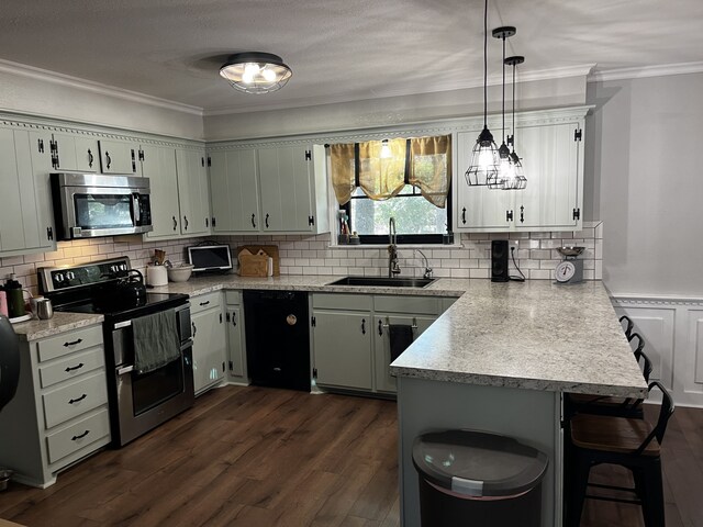 kitchen featuring appliances with stainless steel finishes, sink, dark hardwood / wood-style flooring, kitchen peninsula, and hanging light fixtures