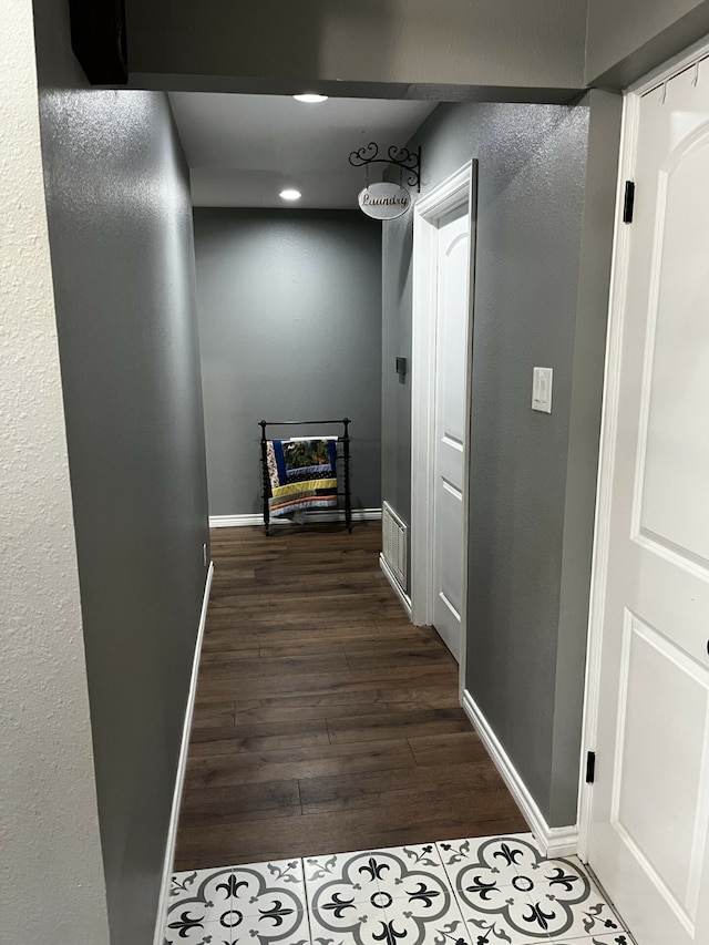 corridor with dark hardwood / wood-style flooring