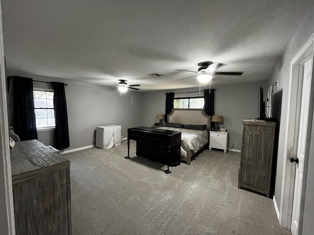 carpeted bedroom with a textured ceiling, multiple windows, and ceiling fan