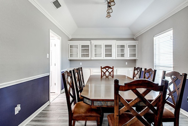 dining area with lofted ceiling, ornamental molding, and hardwood / wood-style flooring