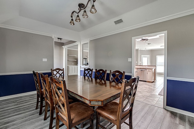 dining room featuring ornamental molding, light wood-type flooring, and ceiling fan