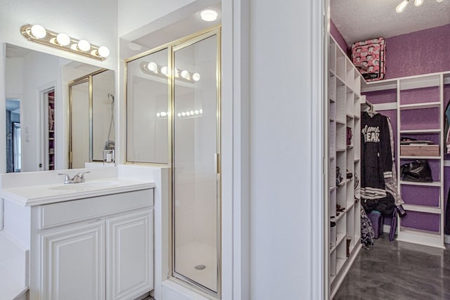 bathroom featuring a shower with door, a textured ceiling, and vanity