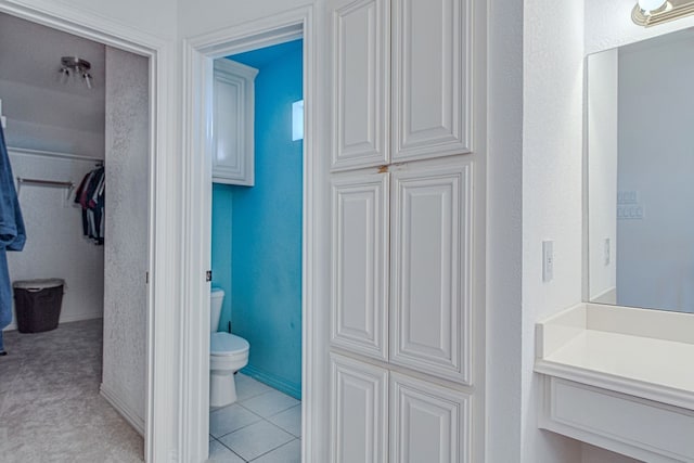 bathroom with toilet, vanity, and tile patterned floors