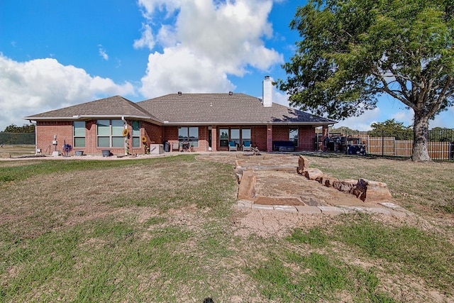 back of house with a yard and a patio