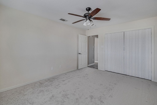 unfurnished bedroom with light carpet, a closet, and ceiling fan