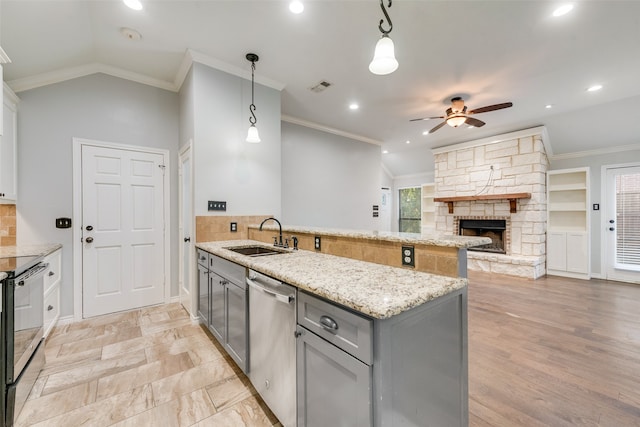 kitchen with sink, gray cabinetry, stainless steel dishwasher, pendant lighting, and a fireplace