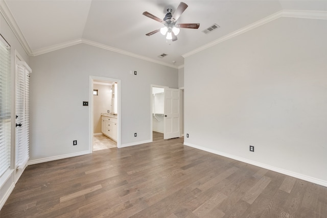 unfurnished bedroom with connected bathroom, a walk in closet, and hardwood / wood-style flooring