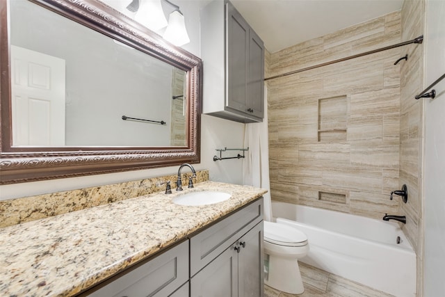 full bathroom featuring vanity, tiled shower / bath, and toilet