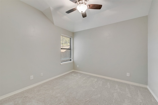 spare room featuring light carpet, ceiling fan, and vaulted ceiling