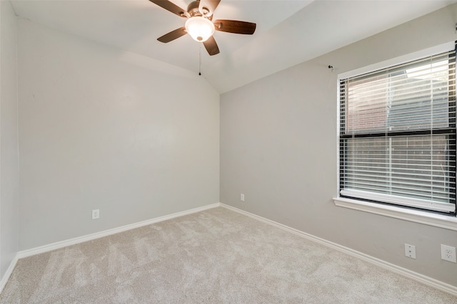 empty room featuring ceiling fan, light colored carpet, and vaulted ceiling