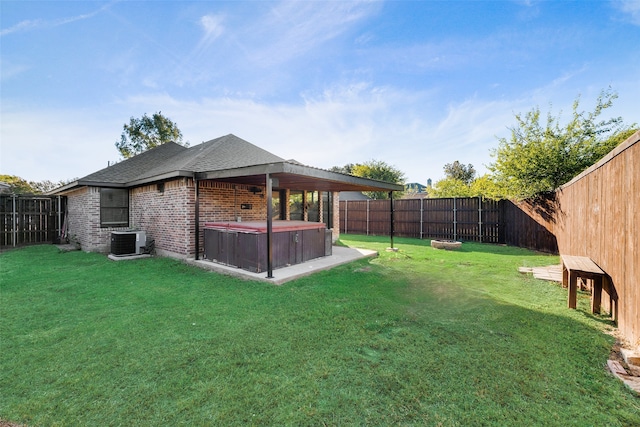 view of yard with a hot tub and central air condition unit