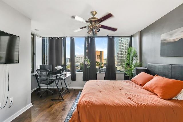 bedroom with ceiling fan, dark hardwood / wood-style flooring, and a wall of windows