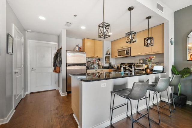 1200 Main St Unit 503, Dallas, TX 75202 - kitchen with dark countertops, appliances with stainless steel finishes, a peninsula, and visible vents