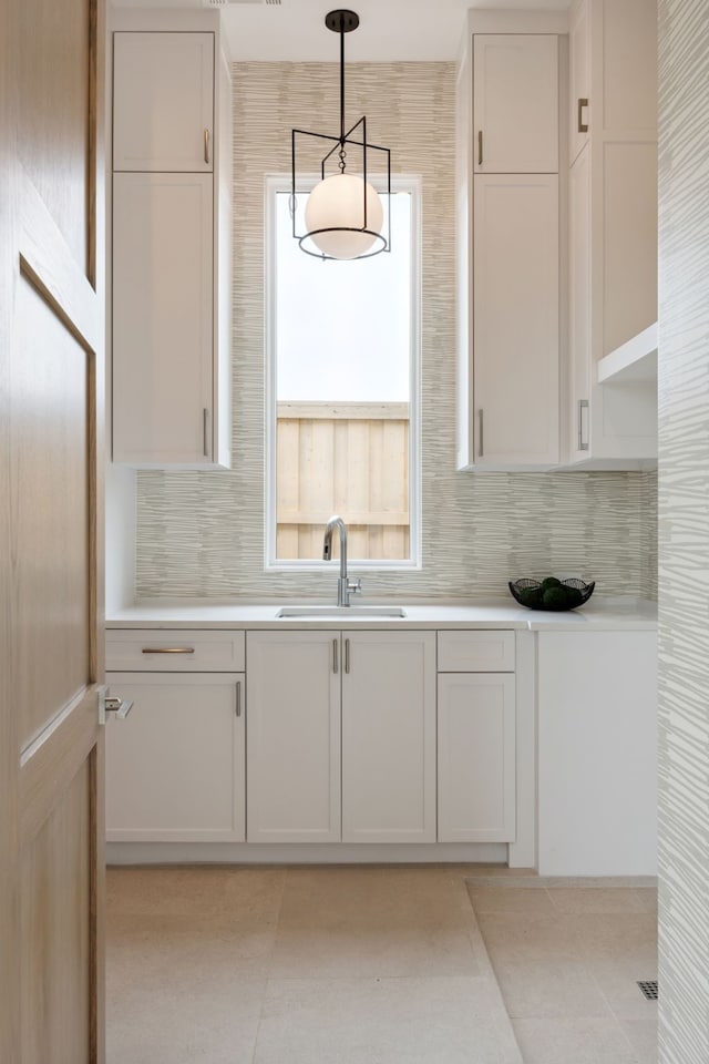 kitchen featuring tasteful backsplash, a sink, and light countertops