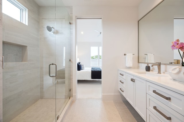 ensuite bathroom with vanity, a wealth of natural light, a shower stall, and connected bathroom