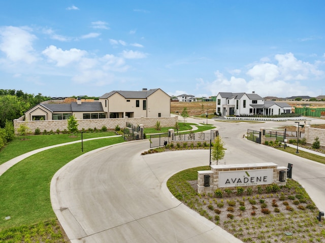 exterior space with a front lawn, curved driveway, a residential view, and stucco siding