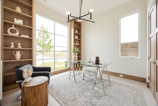 office space with a wealth of natural light, a notable chandelier, built in features, and baseboards
