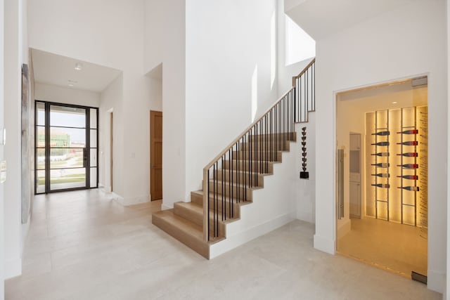 stairs with baseboards and a towering ceiling