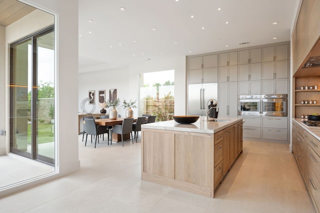 kitchen featuring a sink, a kitchen island with sink, light tile patterned floors, stainless steel appliances, and recessed lighting