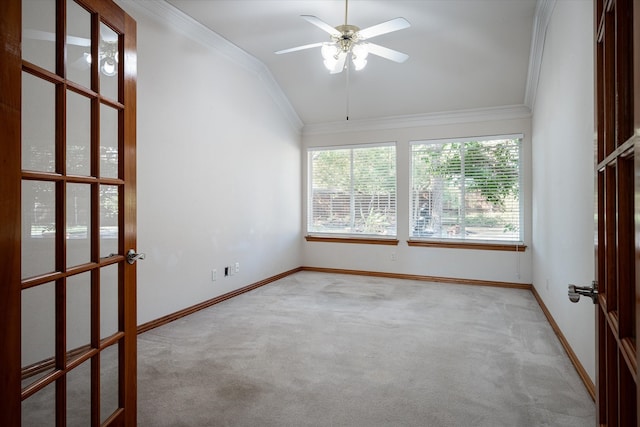 empty room with lofted ceiling, crown molding, and light carpet