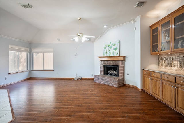 unfurnished living room with vaulted ceiling, crown molding, and dark hardwood / wood-style flooring