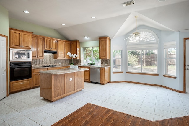 kitchen with black appliances, light tile patterned flooring, a center island, ceiling fan, and lofted ceiling