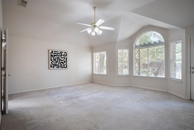 empty room with ceiling fan, light carpet, lofted ceiling, and a wealth of natural light