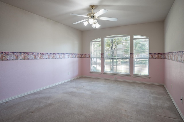 unfurnished room featuring light carpet, ceiling fan, and plenty of natural light