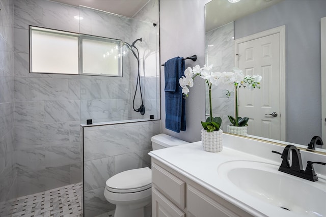 bathroom featuring vanity, toilet, and tiled shower