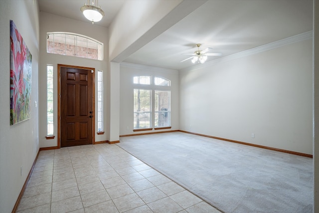 carpeted foyer featuring ceiling fan and crown molding