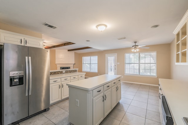 kitchen featuring a center island, white cabinets, stainless steel appliances, and plenty of natural light