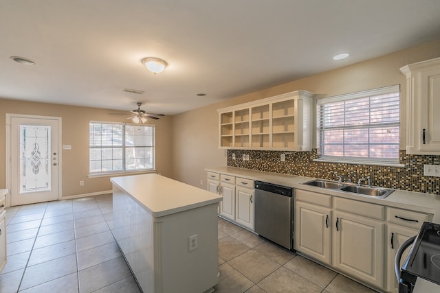 kitchen featuring dishwasher, backsplash, range, a center island, and white cabinetry