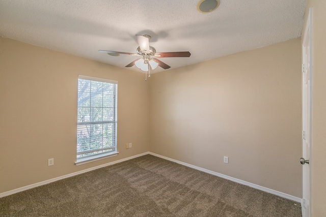 carpeted spare room with ceiling fan and a textured ceiling