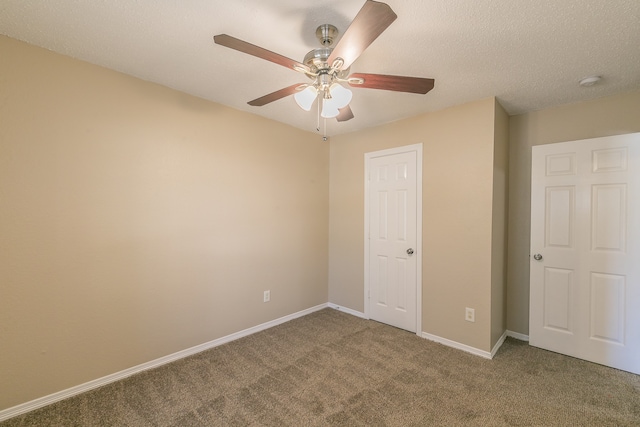 unfurnished bedroom featuring a textured ceiling, carpet floors, and ceiling fan