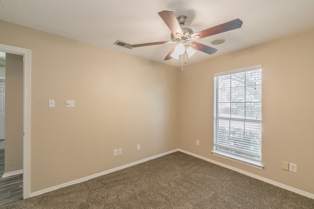 carpeted spare room featuring ceiling fan and a textured ceiling