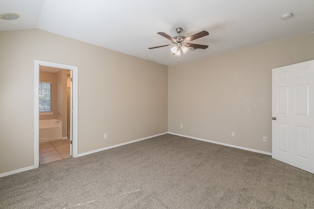 carpeted spare room with vaulted ceiling and ceiling fan