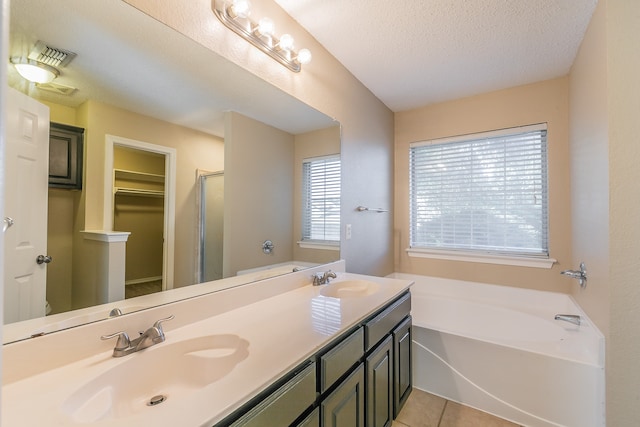 bathroom featuring vanity, plus walk in shower, a textured ceiling, and tile patterned flooring