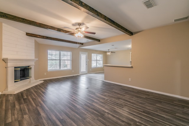 unfurnished living room featuring beamed ceiling, dark wood-type flooring, and ceiling fan