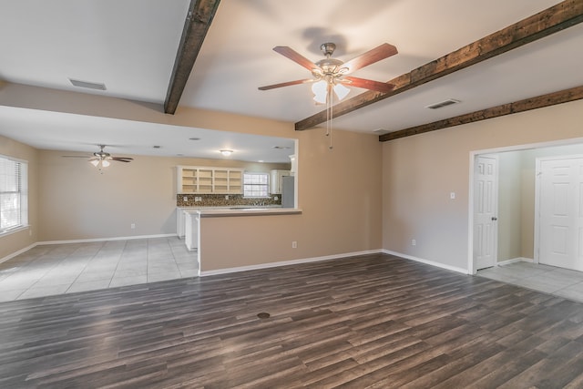 unfurnished living room with hardwood / wood-style floors, beamed ceiling, and ceiling fan