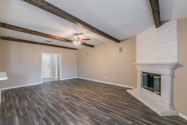 unfurnished living room featuring beam ceiling, a fireplace, dark hardwood / wood-style floors, and ceiling fan