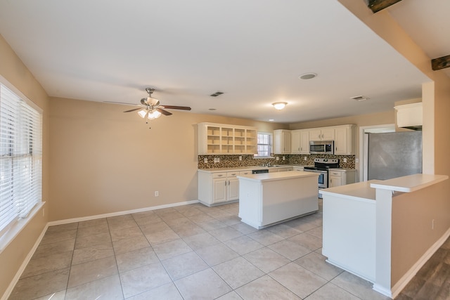 kitchen with decorative backsplash, stainless steel appliances, plenty of natural light, and a kitchen island