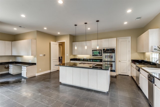 kitchen featuring white cabinets, sink, hanging light fixtures, appliances with stainless steel finishes, and a kitchen island