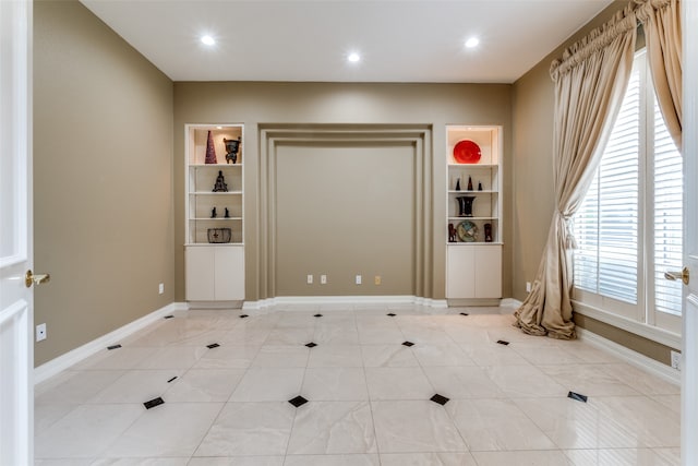 tiled spare room with built in shelves