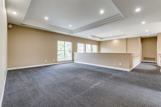 carpeted empty room with a raised ceiling