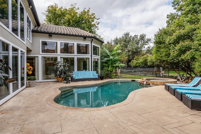 view of pool with a patio area and an in ground hot tub