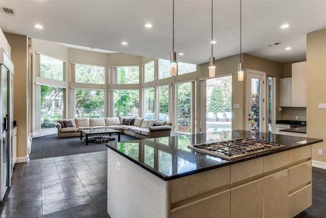 kitchen with a center island, decorative light fixtures, plenty of natural light, and stainless steel gas stovetop