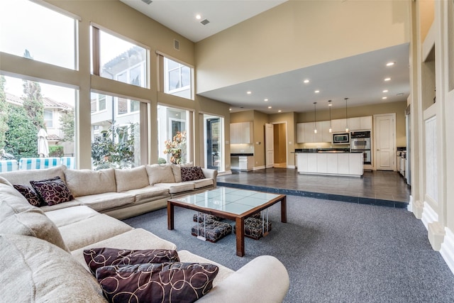 living room featuring dark tile patterned floors and a high ceiling